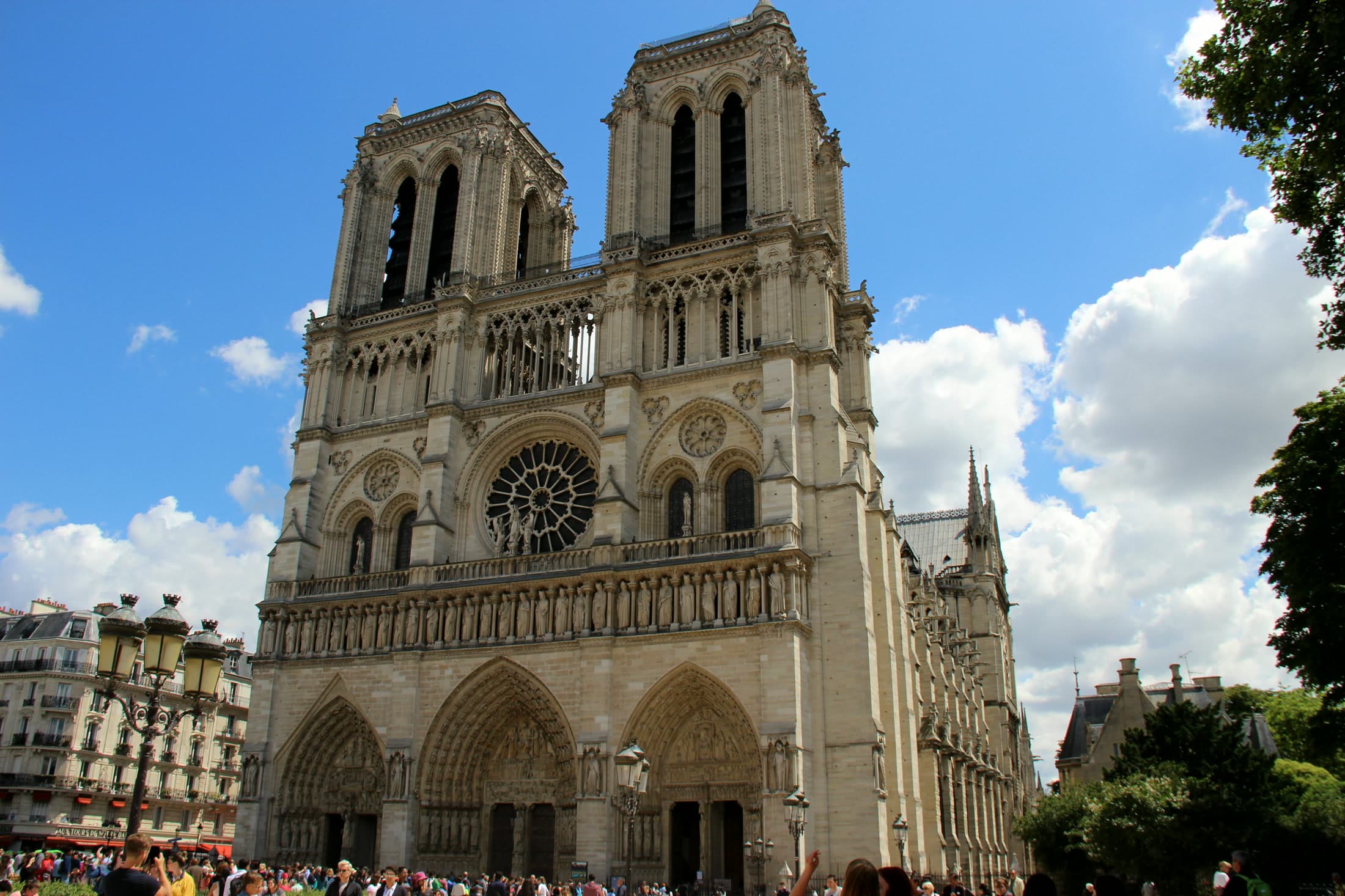 Front view of Notre Dame Cathedral in Paris with its twin towers centered above the plaza.